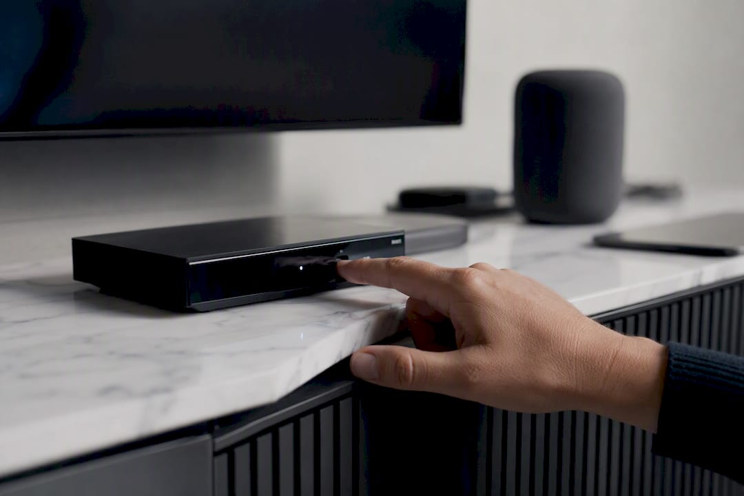 Hand pressing reset button on IPTV device